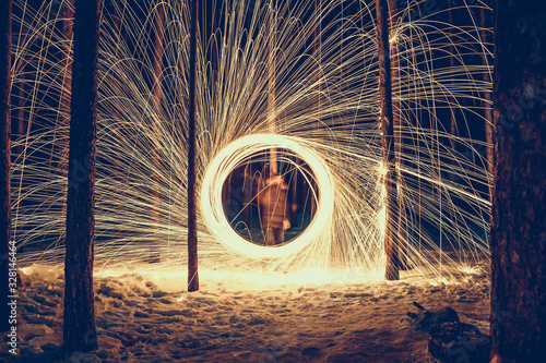 freezelight with steel wool against a gloomy winter forest photo