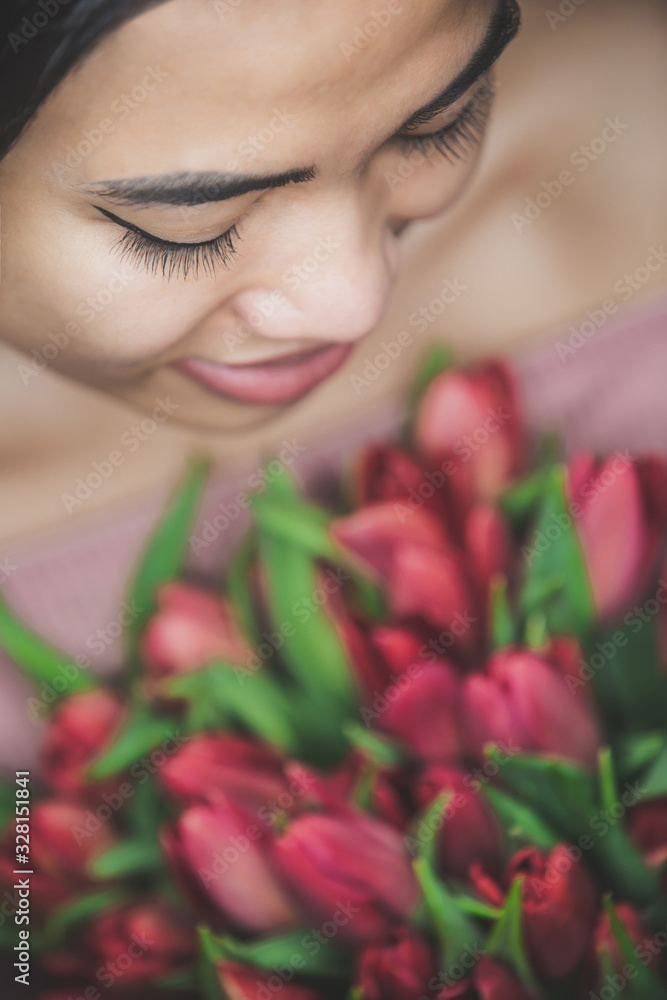 Woman smiling holding a bouquet of tulip flowers Woman smiling holding a bouquet of tulip flowers