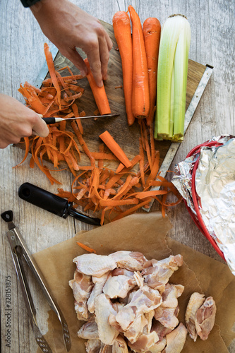 Wings: Man Cutting Carrots To Go With Chicken photo