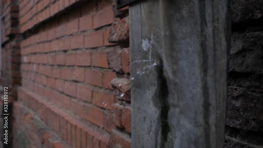 Static slow motion view of rain water flying out of a hole on a rusted, old drain pipe on the side of a red brick wall Static slow motion view of rain water flying out of a hole on a rusted, old drain pipe on the side of a red brick wall