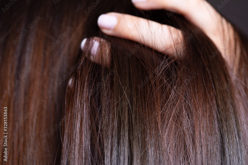 Close up view of glossy brown hair. Brunette woman long hair flows among defocused fingers. Shampoo product concept. Copy space. Close up view of glossy brown hair. Brunette woman long hair flows among defocused fingers. Shampoo product concept. Copy space.