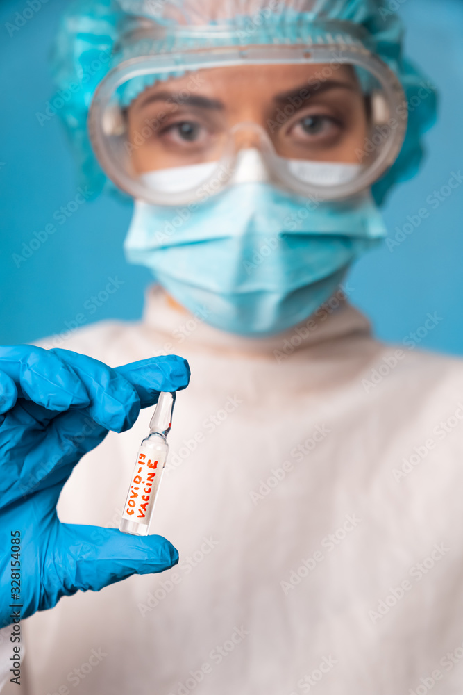 A female doctor, an employee of a scientific laboratory, holds in her hand a medical ampoule with a vaccine against coronavirus. COVID-19. 2019 Novel Coronavirus (2019-nCoV). A female doctor, an employee of a scientific laboratory, holds in her hand a medical ampoule with a vaccine against coronavirus. COVID-19. 2019 Novel Coronavirus (2019-nCoV).