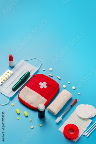 Flat lay Medicines and devices for first aid, bandages, painkillers, plaster, cotton wool, tampon on a blue background photo