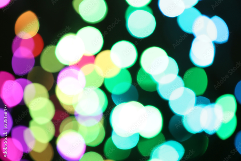 Blurred view of colorful lights on black background. Bokeh effect