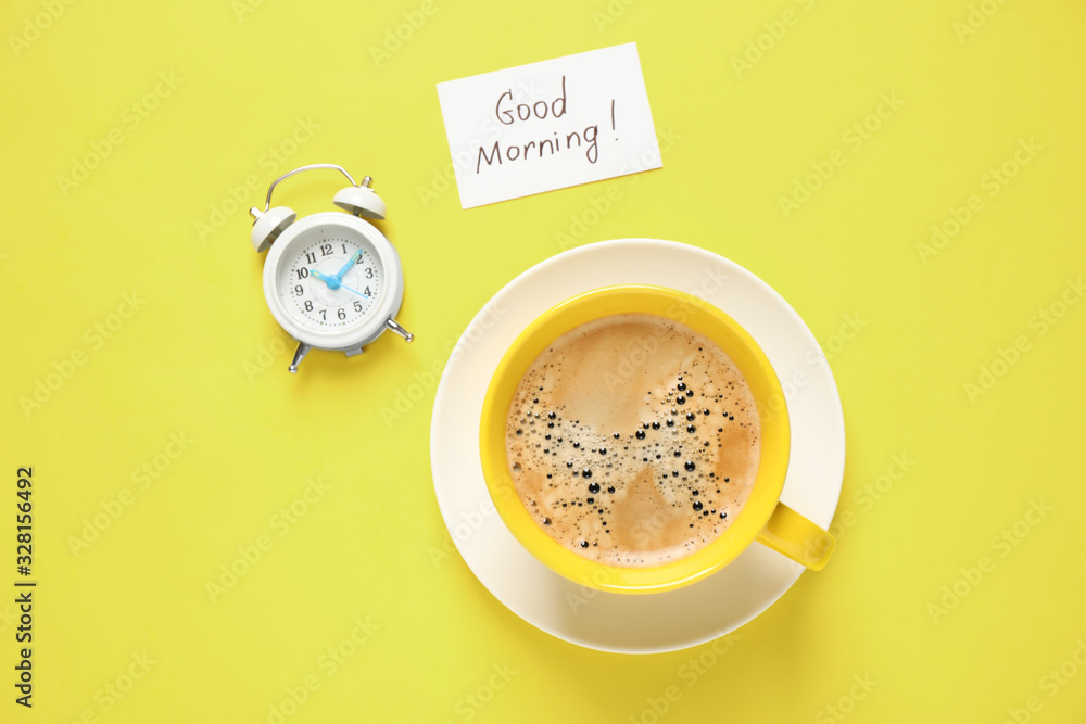 Delicious coffee, alarm clock and card with GOOD MORNING wish on yellow background, flat lay Delicious coffee, alarm clock and card with GOOD MORNING wish on yellow background, flat lay