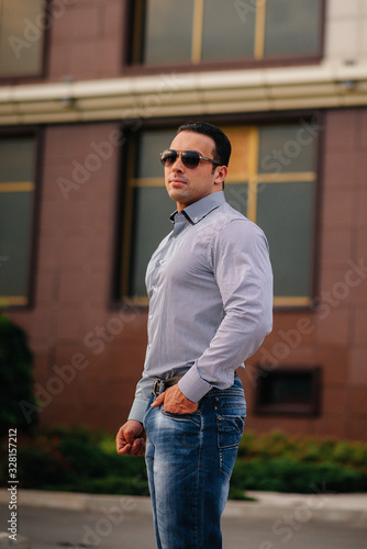 Young successful man near an office building. Business