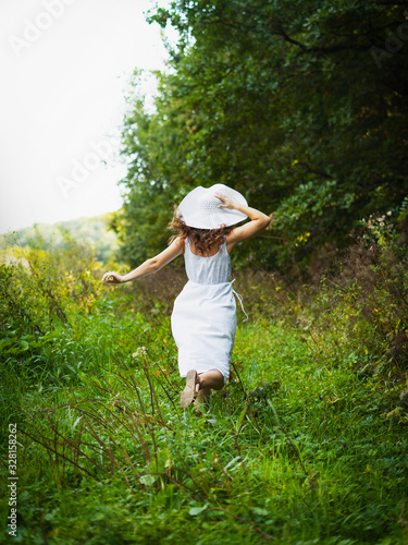 A woman in a dress. Woman in the park. A woman walks in the park in a white dress © chdenisz