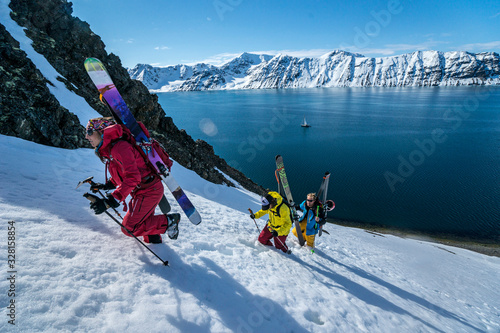 Group of friends skinning up mountain to ski in Svalbard photo