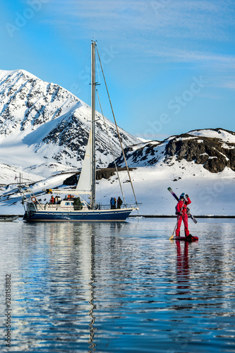 Woman paddleboarding in Jan Mayen on ski trip photo