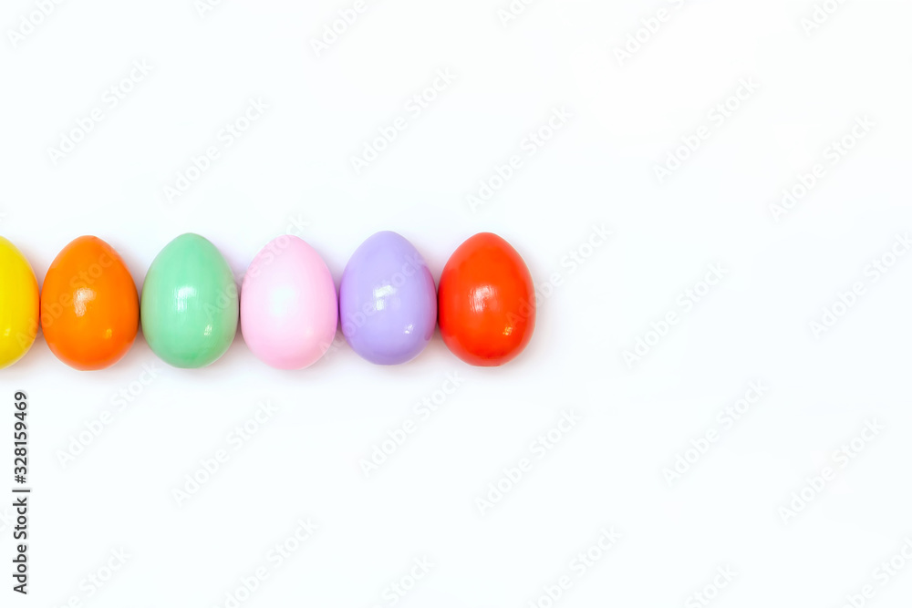 Top view of an Easter composition of painted eggs in bright juicy colors on a white background with a glossy texture. Holiday concept, flat layout, minimalism Top view of an Easter composition of painted eggs in bright juicy colors on a white background with a glossy texture. Holiday concept, flat layout, minimalism