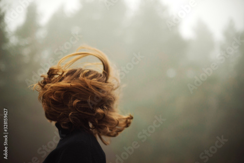 woman standing by forest in foggy weather photo