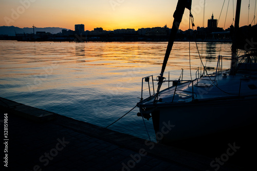  vistas al Palmeral de las Sorpresas en Puerto de Malaga en la puesta de sol. se aprecia una embarcación en primer plano y de fondo la ciudad en landscape, se divisa la catedral