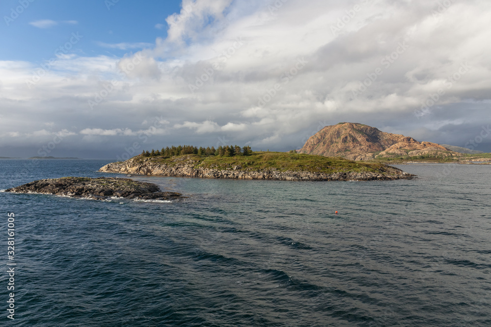 Fototapeta premium Norwegian fjord and mountains surrounded by clouds, ideal fjord reflection in clear water. selective focus.