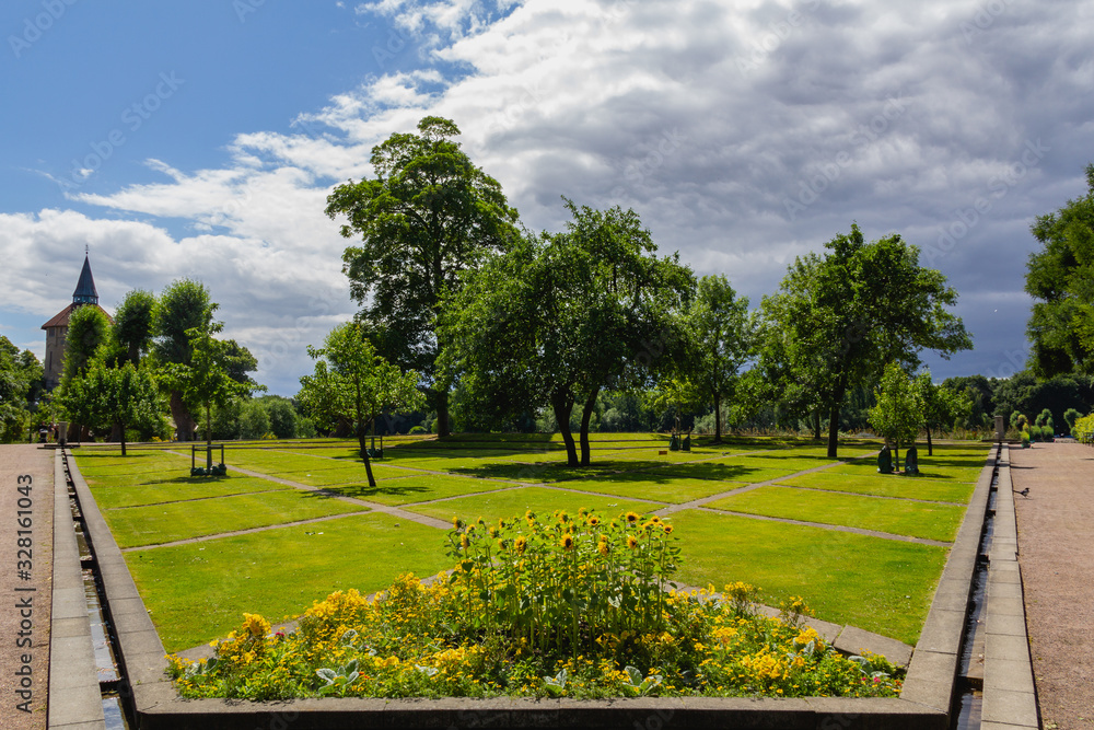 Fototapeta premium The park Pildammsparken looks lush with green trees, green fields and sunflowers in full bloom on a summer day in Malmö, Sweden