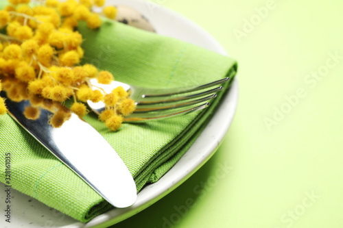 Festive Easter table setting with floral decor on green background, closeup