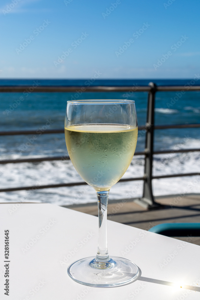Summer holiday on sea, drinking white wine on outdoor terrace with sea view in sunny day