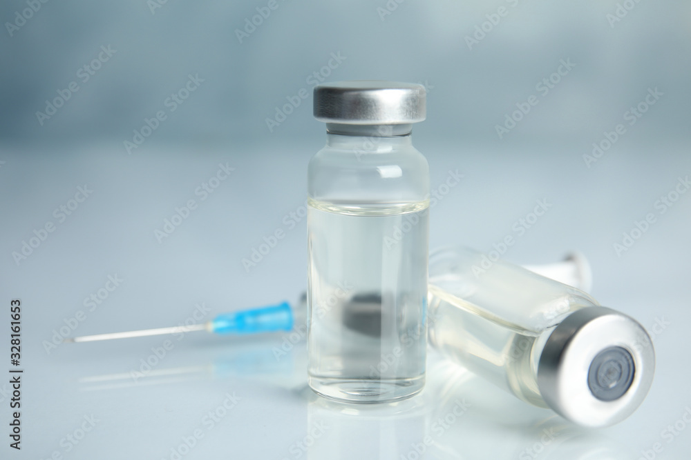 Vials and syringe on light table. Vaccination and immunization Vials and syringe on light table. Vaccination and immunization