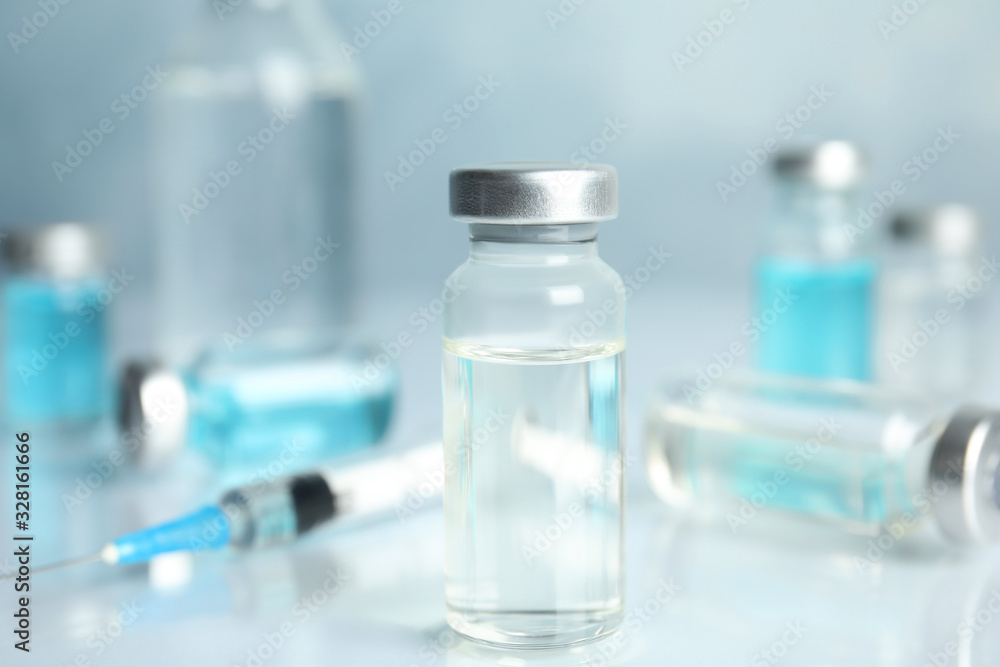 Vials and syringe on light table. Vaccination and immunization Vials and syringe on light table. Vaccination and immunization