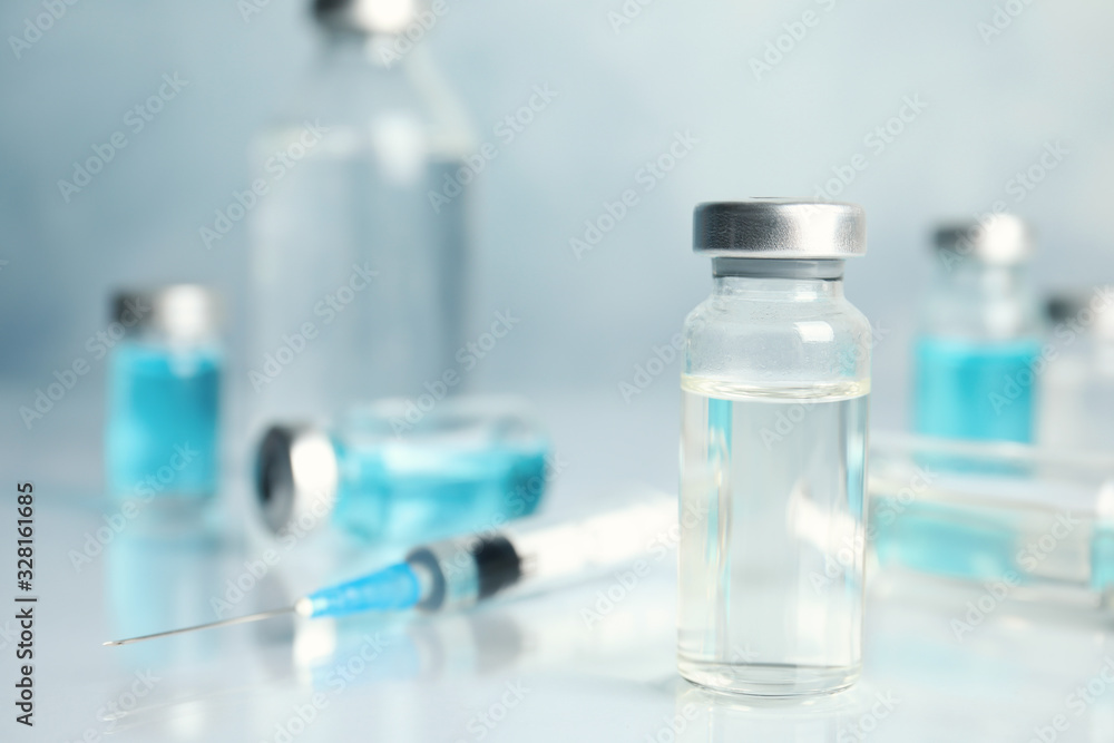Vials and syringe on light table. Vaccination and immunization Vials and syringe on light table. Vaccination and immunization