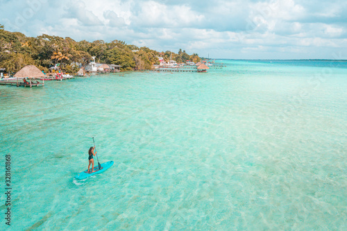 Fotografie Girl doing paddleboard in Bacalar Lagoon, near Cancun in Riviera Maya, Mexico