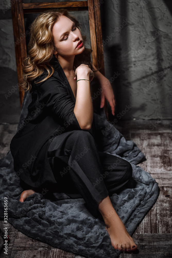 Fototapeta premium Girl in a Jacket, Pants and Sexy Lingerie Posing in a Studio. Model sensually posing in retro loft interior