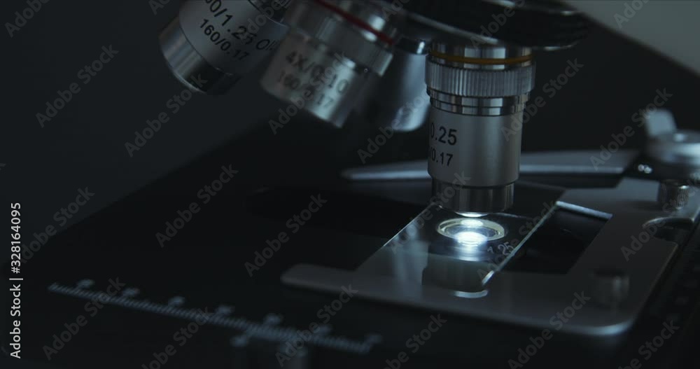 Crop closeup shot of microscope in the laboratory, scientist is conducting study examines the sample on a slide Crop closeup shot of microscope in the laboratory, scientist is conducting study examines the sample on a slide