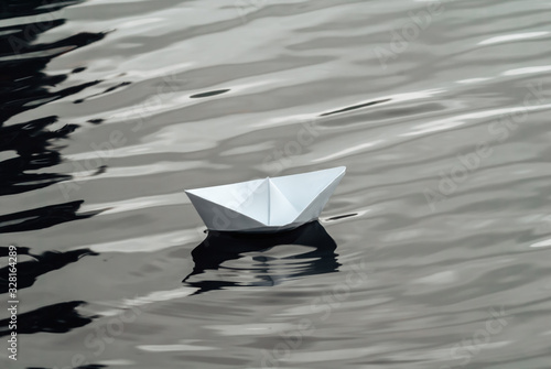 paper boat sailing on water with waves and ripples