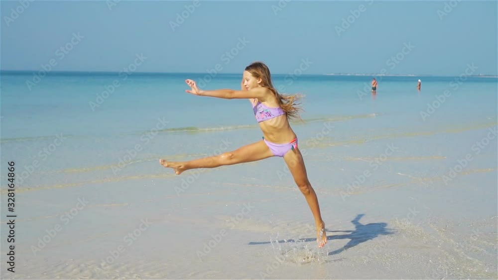 Adorable active little girl at beach during summer vacation Adorable active little girl at beach during summer vacation