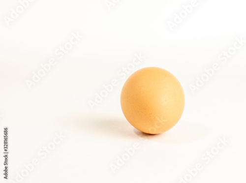 one fresh brown chicken egg on a white background