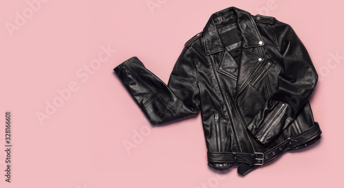 Tableau sur toile Black women's leather jacket on pink background top view