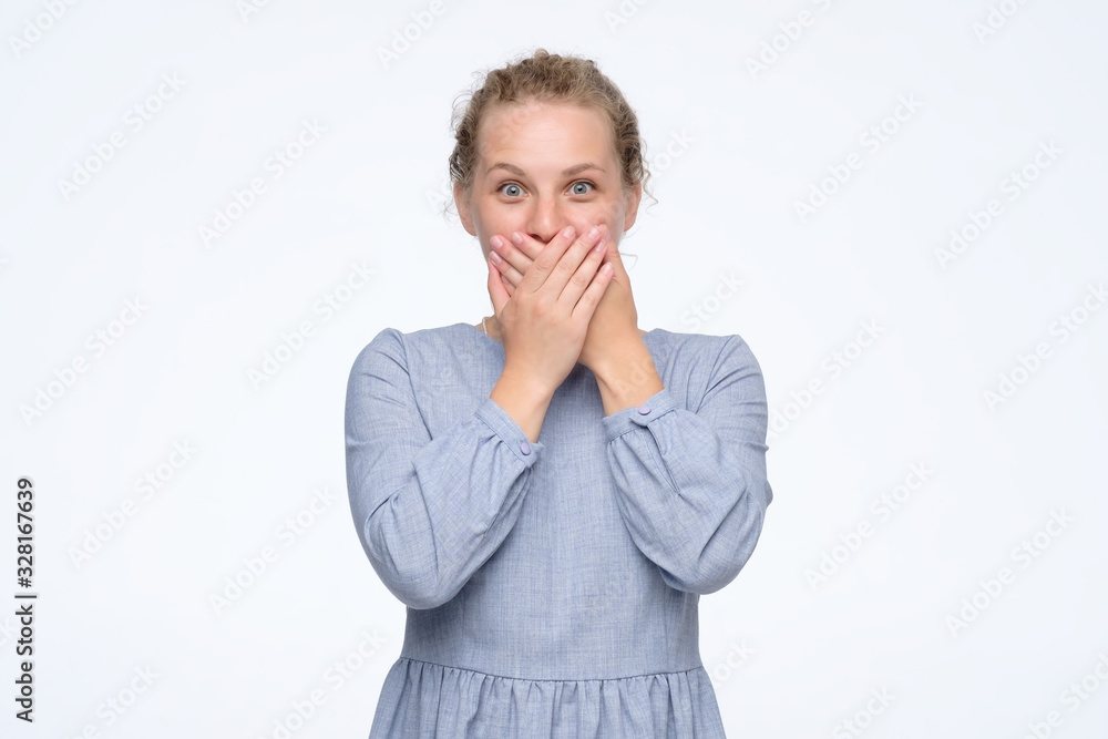 Scared young curly woman covering mouth with hands being scared. Scared young curly woman covering mouth with hands being scared.