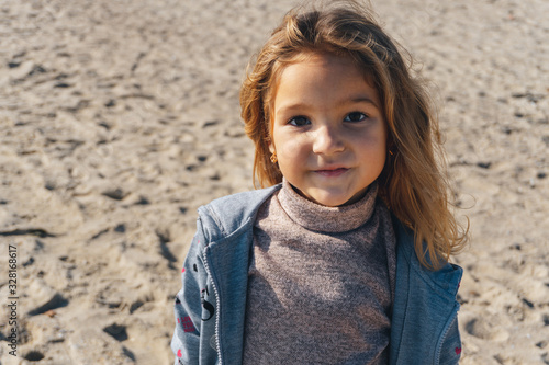 Portrait of a little girl on the sea sandy shore