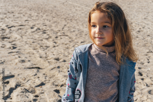Portrait of a little girl on the sea sandy shore