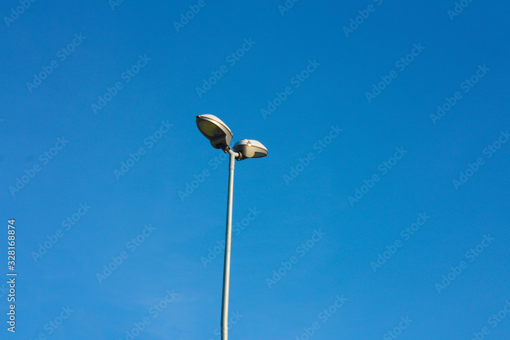 slim and lonely lamppost in contrast against the clear blue sky slim and lonely lamppost in contrast against the clear blue sky