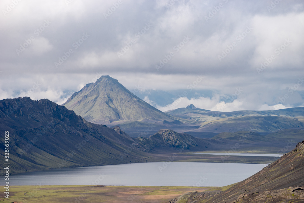 Fototapeta premium View mountain valley with green hills, river stream and lake. Laugavegur hiking trail, Iceland
