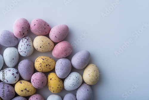 Colorful mini Easter eggs on a plain back ground with copy space