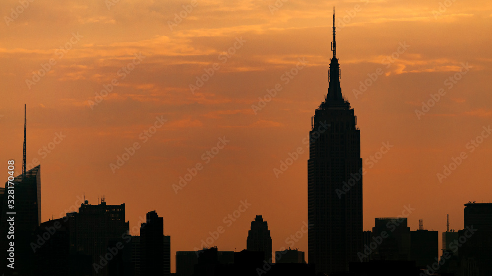 Landmarks of america and american financial district concept with silhouette of the midtown manhattan skyscrapers skyline in New York City, NY at dawn with copy space