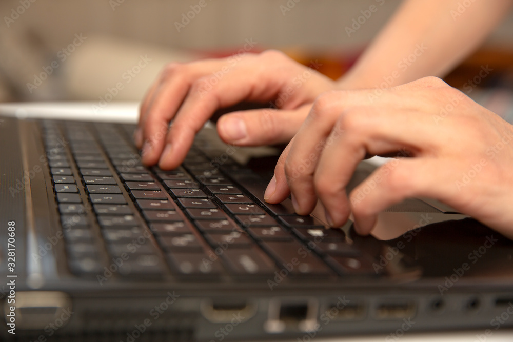 Side view of the hands of a beautiful young hipster woman busy on her laptop