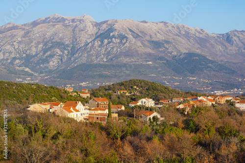 Beautiful winter Mediterranean landscape. Village in mountains. Montenegro, historical region of Krtoli  on Lustica peninsula against Lovcen mountain. View of  Bogisici village photo