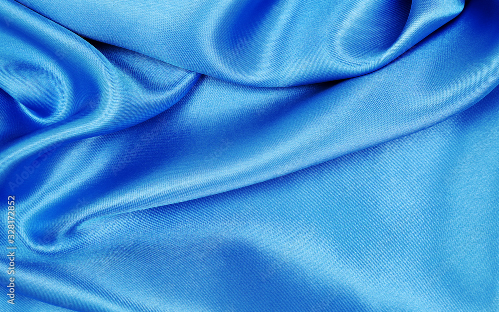 Smooth elegant blue silk or satin luxury cloth texture as abstract background. Luxurious background design