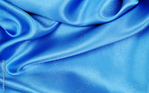 Smooth elegant blue silk or satin luxury cloth texture as abstract background. Luxurious background design