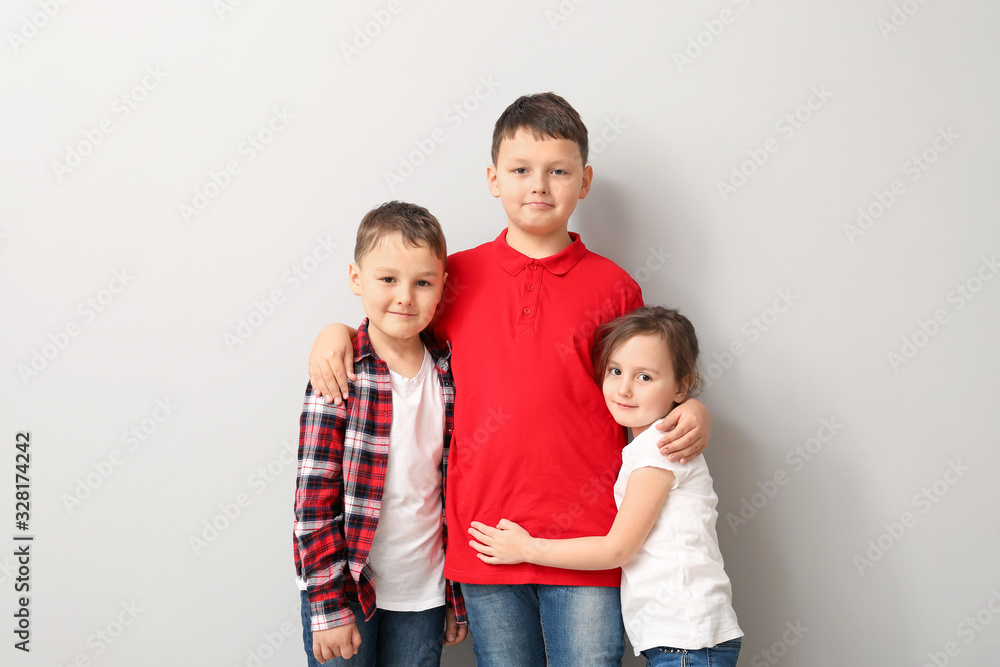 Portrait of happy brothers and sister on light background Portrait of happy brothers and sister on light background