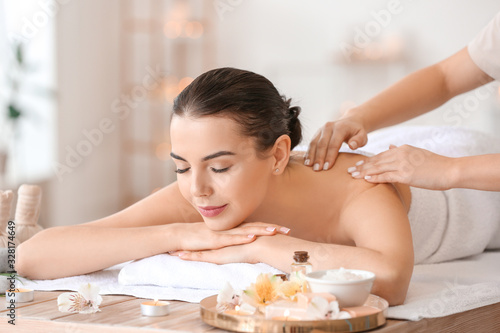 Beautiful young woman receiving massage in spa salon photo