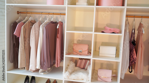 Close-up of interior design wardrobe. Modern light women's dressing room with various things.
