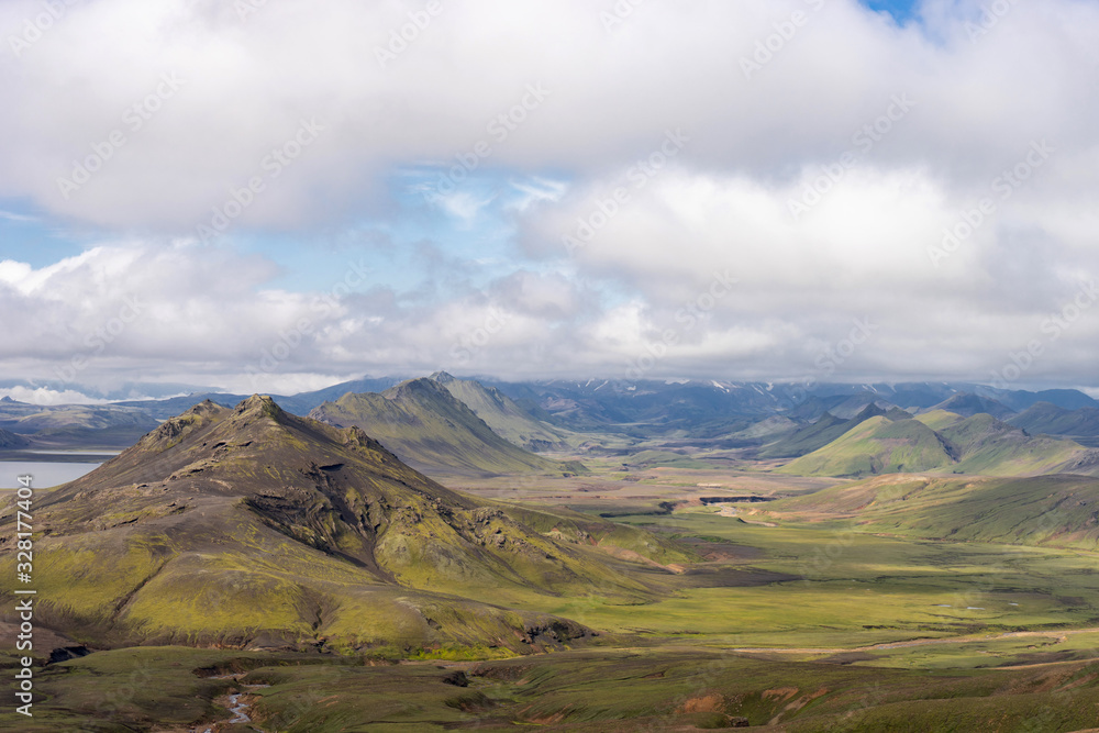 View mountain valley with green hills, river stream and lake. Laugavegur hiking trail, Iceland View mountain valley with green hills, river stream and lake. Laugavegur hiking trail, Iceland