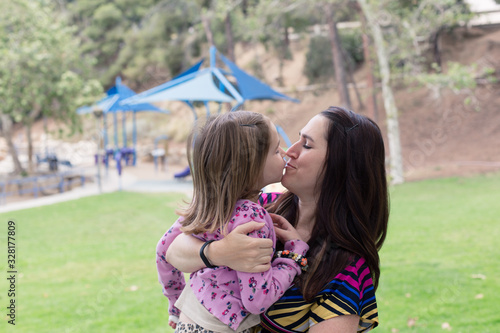 A mother and daughter are enjoying each others company at a park in the summertime. 