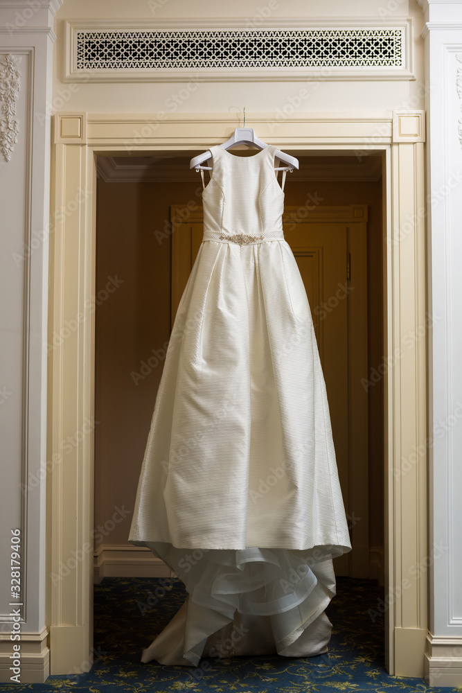 Wedding dress hanging up by the door. Wedding dress hanging up by the door.
