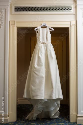 Wedding dress hanging up by the door.