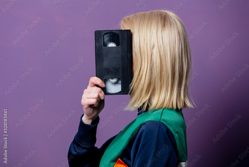 Style blonde woman in 80s clothes with VHS Style blonde woman in 80s clothes with VHS