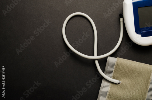 Digital blood pressure monitor, on black background. Top view.